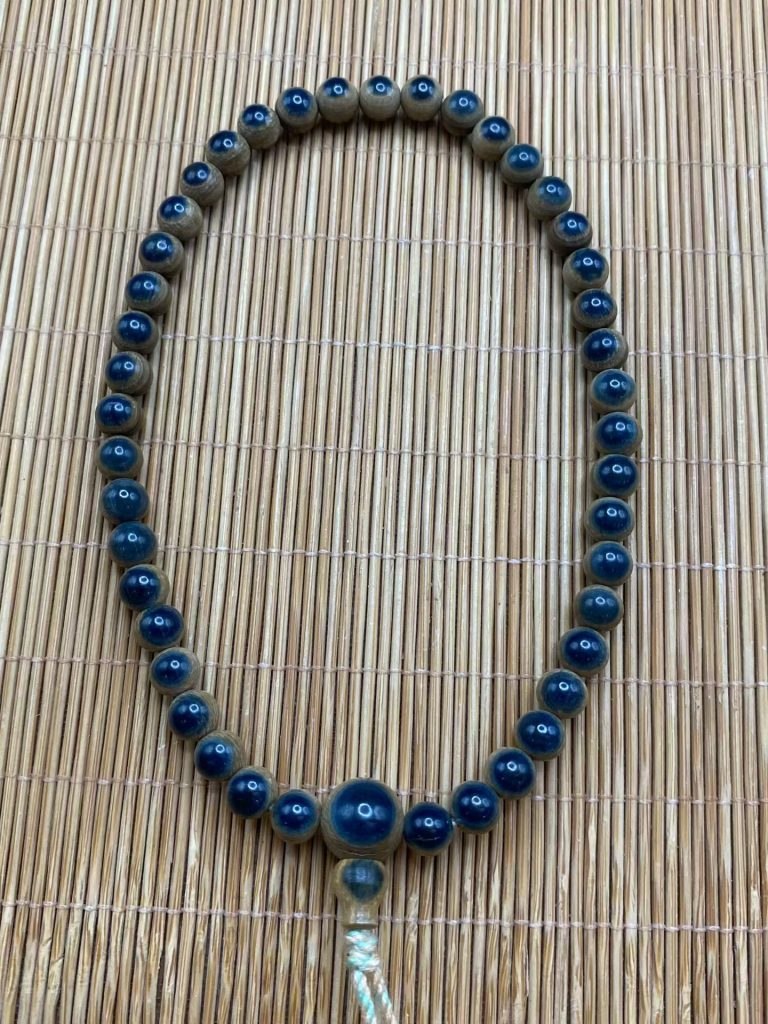 在猛犸象牙手串中，“蓝眼睛”一直是老玩家和收藏者心中的精品存在。它并不是后期染色或人工处理，而是源自猛犸象牙天然外层皮壳所呈现出的独特色泽。今天这串 6mm 猛犸象牙蓝眼睛手串（108颗），正是典型的高品质蓝皮咖啡材料代表。
一、什么是猛犸象牙蓝眼睛？
所谓“蓝眼睛”，指的是在车珠时，完整保留了猛犸象牙外层蓝皮，并且蓝皮在珠子正面形成清晰、饱满的“眼状结构”。
真正好的蓝眼睛，必须满足三个条件：
蓝色自然、不发灰、不死蓝
眼睛完整、集中、不散
蓝皮与牙肉分界清晰
这串手串的蓝眼睛，正是由天然猛犸象牙外层皮直接车制而成，而非后期处理，每一颗都能看到明显而深邃的蓝色视觉效果。
二、6mm 108颗，难得的统一度
猛犸象牙蓝眼睛珠子，本身出材率就不高，而要做到：
108颗完整成串
尺寸统一（6mm）
每一颗都有明显蓝眼
对原料和工艺的要求都非常高。
这串手串整体排列规整，大小误差极小，蓝眼分布均匀，视觉连贯性极强，上手后整体感非常好，既适合日常佩戴，也适合作为长期盘玩的对象。
三、蓝皮 + 咖啡牙肉，层次分明
除了蓝眼睛本身，这串手串的牙肉颜色同样出色。
牙肉呈现出浓郁、温润的咖啡色调，不是发白、发灰的浅料，而是老料才会有的厚实感。
蓝皮的冷色调，与咖啡牙肉的暖色调形成自然对比，使每一颗珠子都具备明显的层次感，这正是天然猛犸象牙材料最迷人的地方。
四、为什么蓝眼睛猛犸象牙越来越受欢迎？
近年来，猛犸象牙饰品逐渐从“量”走向“质”，玩家更看重：
材料是否天然
皮肉结构是否清晰
是否具备可盘性和变化空间
蓝眼睛手串在长期佩戴、把玩后，牙肉会逐渐油润，蓝皮颜色也会更加沉稳，整体观感会不断提升，这也是它深受资深玩家喜爱的原因。
五、总结
这串 猛犸象牙蓝眼睛手串（6mm / 108颗），选用天然猛犸象牙蓝皮咖啡材料，蓝眼清晰、颜色纯正，珠子大小统一，牙肉色泽浓郁，是一串兼具观赏性与收藏价值的精品手串。
无论是初入猛犸象牙圈，还是已有多年盘玩经验，这样一串用料扎实、特征明显的蓝眼睛手串，都值得细细品味。